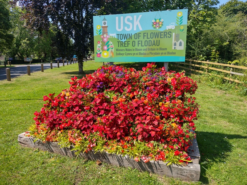 "Usk in Bloom" sign